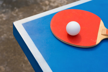 pingpong rackets and ball on a blue table