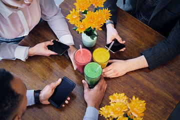 People's arms, smartphones and  vegetarian juice.