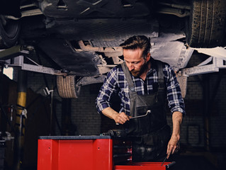 Obraz na płótnie Canvas Mechanics choose a removal tool for fixing the car.