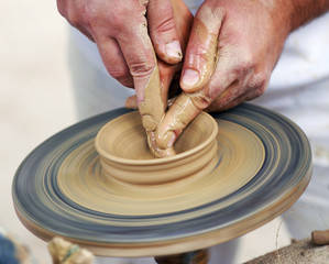 Hands working on pottery wheel