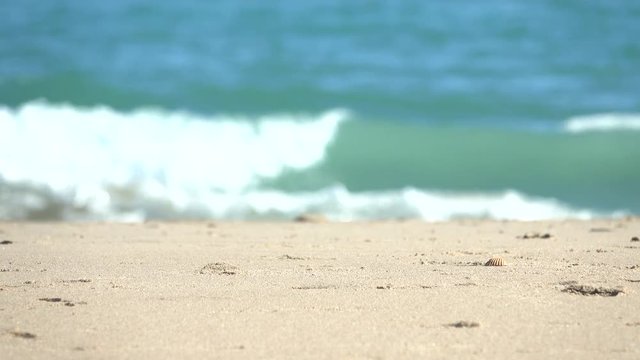 Beach sand focused on unfocused sea background.