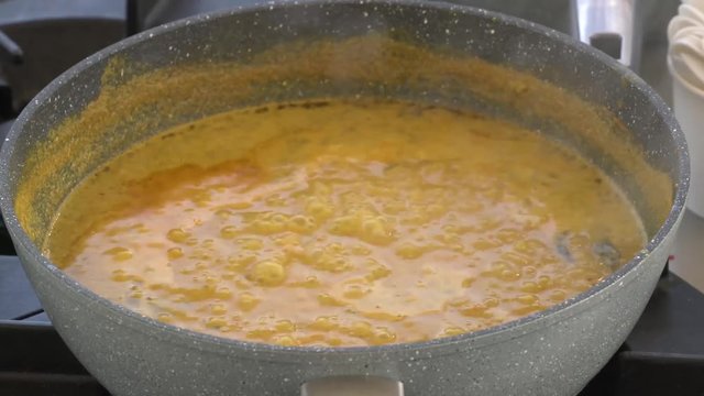 Shot of a bubbling and boiling pot with curry sauce.