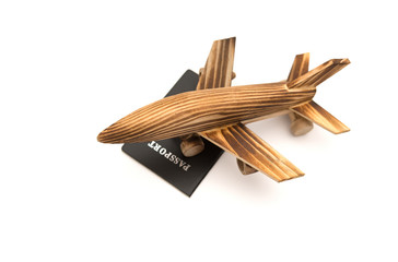 airplane model on top of a passport on white background