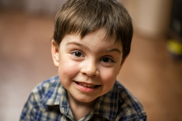 Boy brunette in checkered shirt with brown eyes shows class and smiles