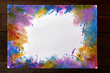Watercolor brush stroke frame border painting on paper with place for text on wooden background. Artistic abstract background.