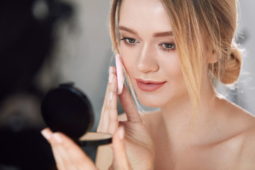 Face Make-Up. Female With Mirror Putting Cosmetic Powder
