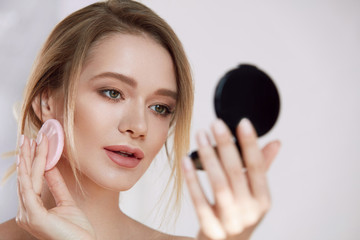 Face Make-Up. Female With Mirror Putting Cosmetic Powder © puhhha