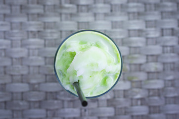 top view glass of green tea frappe , ice shake .