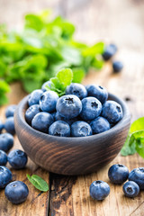 Fresh blueberries in bowl on wooden table