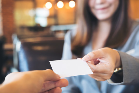 Business Woman Exchange Business Card With Business Man In Coffee Shop