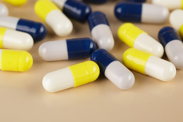 Heap of blue and yellow medicine capsules