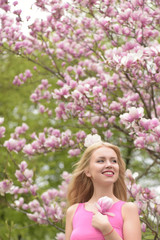 girl in beautiful magnolia flowers pink color tree