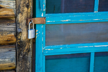 Locked Blue Screen Door On Rustic Cabin