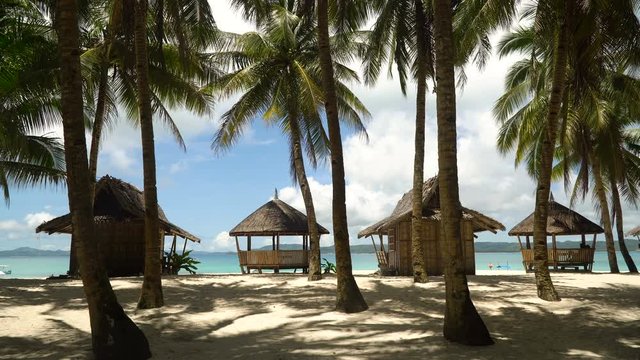 Beach with white sand with beach house on a tropical island Daco. Beautiful sky, sea, resort. Seascape: Ocean and beautiful beach paradise. Philippines. 4K video. Travel concept.