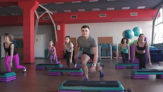 fitness, sport, training, gym and lifestyle concept - group of women working out with steppers in gym