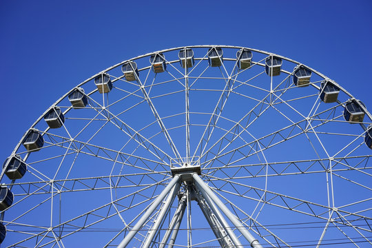 Ferris wheel Ferris wheel with closed cabins on the background of bright blue sky