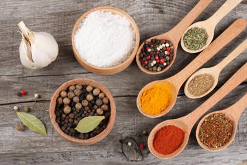 spices in spoon on old wood background