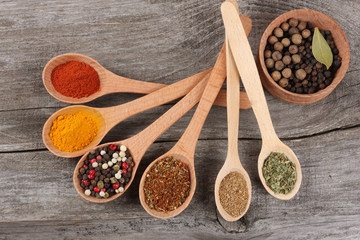 spices in spoon on old wood background
