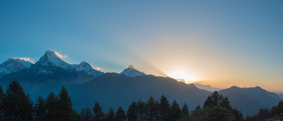 Poon hill Sunrise over snow-capped mountains with fog and mist in a serene morning landscape