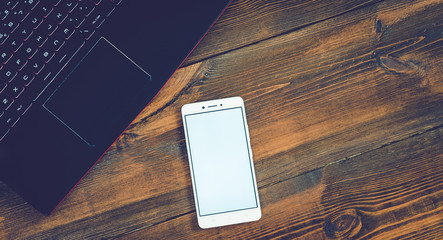Workspace with laptop and smartphone on hard wood desk