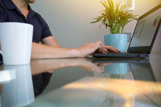 Closeup Cropped Low Angle View Of Man Working On Laptop In Home Office