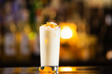 Closeup glass of pina colada cocktail at bright bar counter background. - obrazy, fototapety, plakaty