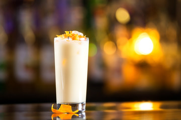 Closeup glass of milk shake cocktail at bright bar counter background. - obrazy, fototapety, plakaty