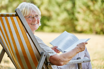 Old lady reading a book and smiling