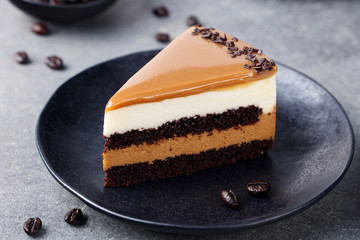 Caramel cake, mousse dessert on a plate. Grey stone background