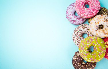 Donuts glazed with sprinkles on pastel blue background.