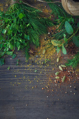 Mix of fresh herbs and spices assortment on wooden background.