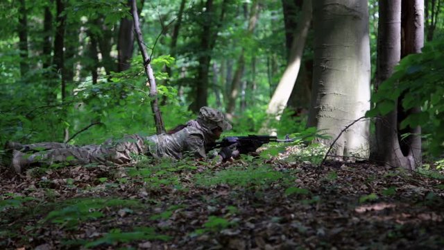 Guerilla partisan warrior sniper aiming in forest ambush carrying his gun. Partisan war reconstruction.