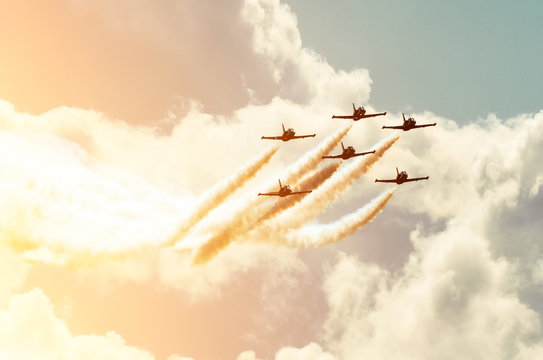 Aircraft fighter jets smoke the background of sky and sun.