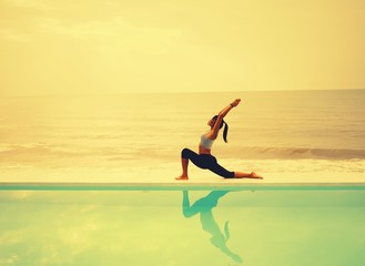 Fototapeta na wymiar Asian woman practice yoga on the beach sunrise