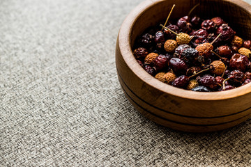 Dried Rosehips in wooden bowl. / kusburnu