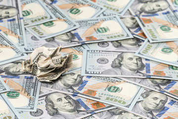 Old crumpled hundred-dollar bill on the background of the new bills spread out next to one another