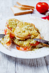 Baked chicken chops with tomato, cheese, dill, greens, spices, garlic and white bread toast on a light wooden background 
