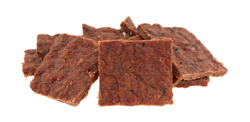 Several pieces of peppered beef jerky isolated on a white background.