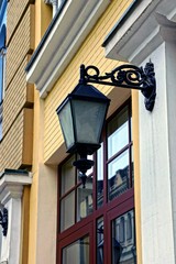 Fototapeta na wymiar Старый уличный фонарь на стене возле окна