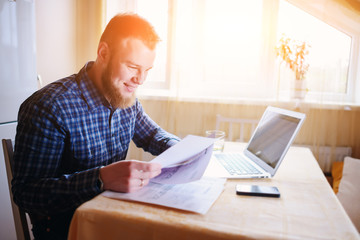 Handsome man doing some paperwork at home