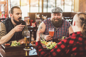 Best friends spending time in pub cheerfully