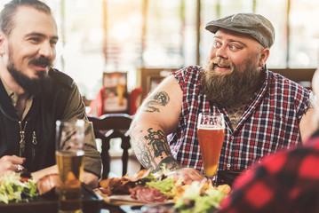Pleasant joyful men sitting at table