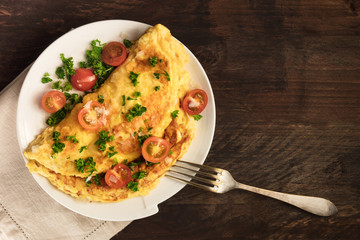 Omelette with parsley, cherry tomatoes, and copyspace