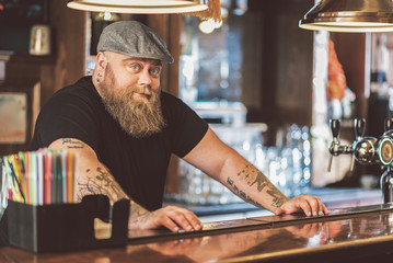 Bearded guy standing at workplace in pub