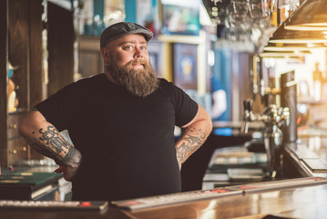Tattooed barman working in pub