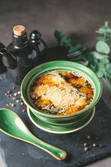 Appetizing fish soup with sesame seeds in green porcelain plate on the gray background. Japanese cuisine.