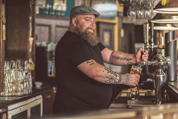 Tattooed man standing at bar counter