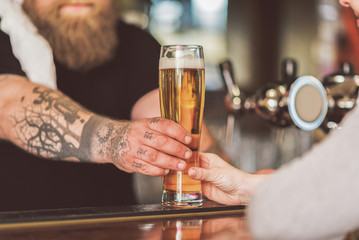Bartender handing customer a drink