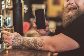 Joyful man showing his handset with smile