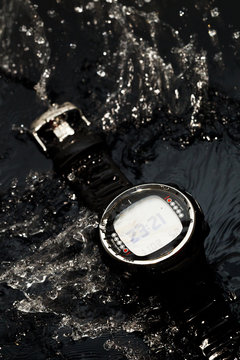 Watches for scuba diving in streams of water on a black background, studio light